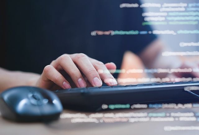 close up image of hands typing on external keyboard