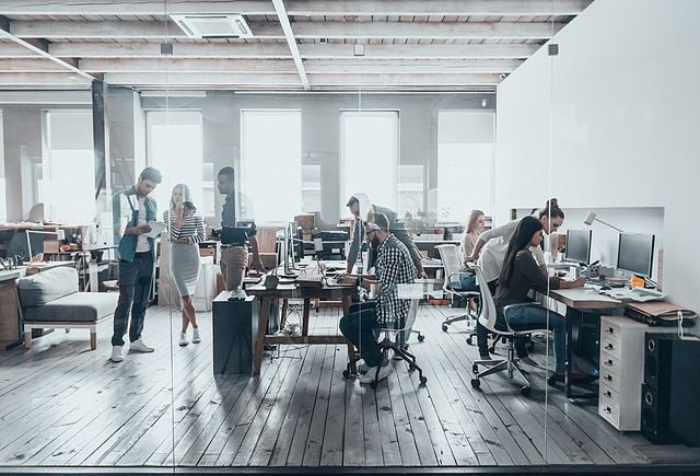 Group of young business people in smart casual wear working together in creative office